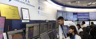 Meteorologists at the Hong Kong Observatory monitor weather data and forecasts on multiple computer screens in a control room.
