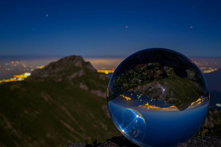 A glass ball on top of a mountain.