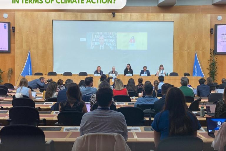 A climate action panel discussion takes place with five speakers on stage and an audience seated in front. The event is part of "The People's Climate Vote" by various environmental organizations.