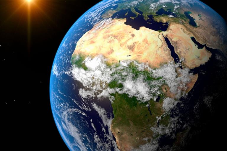 View of Earth from space showing the African continent and surrounding regions. The Sun is visible on the left.