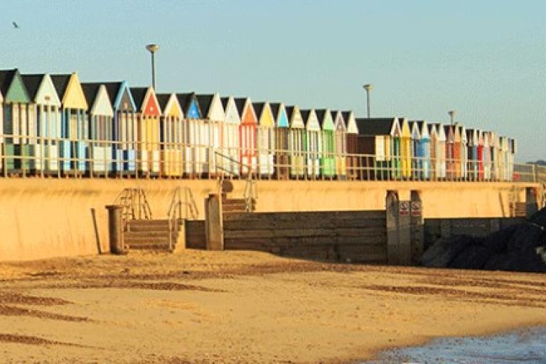A row of colorful huts on a beach.