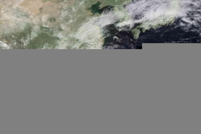 Satellite image showing cloud cover over eastern Asia, including parts of China, Korea, and Japan. The lower portion of the image is partially obscured by a gray glitch.
