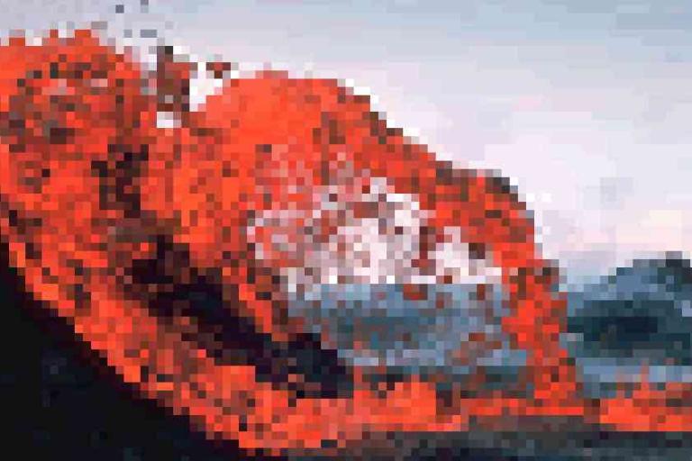 A pixelated image of bright red lava flowing from a volcano with a cloudy sky and distant mountains in the background.