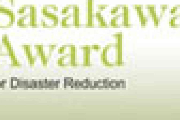 A blurred image with the text "Sasakawa Award for Disaster Reduction" in green and gray letters on a white background.