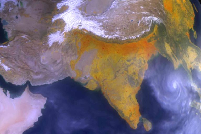 Satellite view showing the Indian subcontinent, parts of the Middle East, and a cyclone spiraling over the Bay of Bengal.