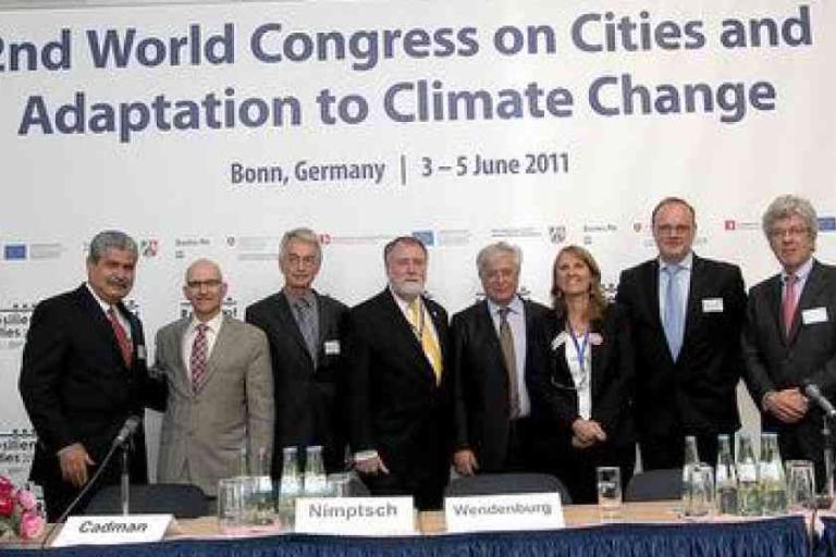 A group of people in formal attire pose in front of a banner for the 2nd World Congress on Cities and Adaptation to Climate Change, held in Bonn, Germany, June 3-5, 2011.