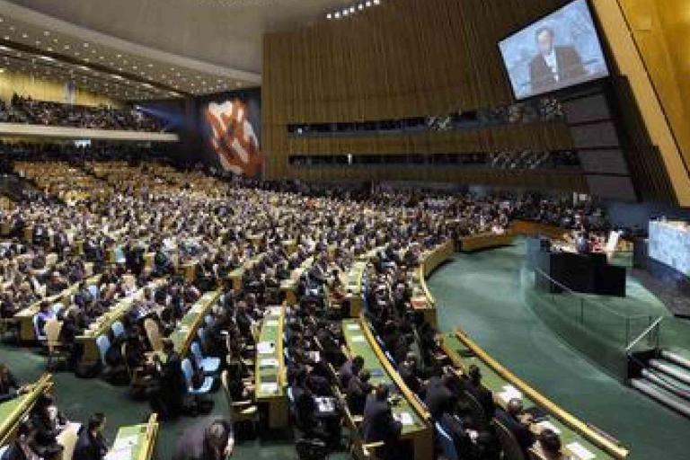 A large assembly of delegates seated in the United Nations General Assembly Hall, with a speaker addressing the audience from a podium.