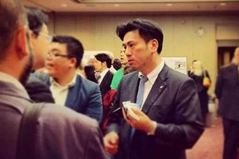 A group of people in business attire conversing at an indoor networking event or conference.