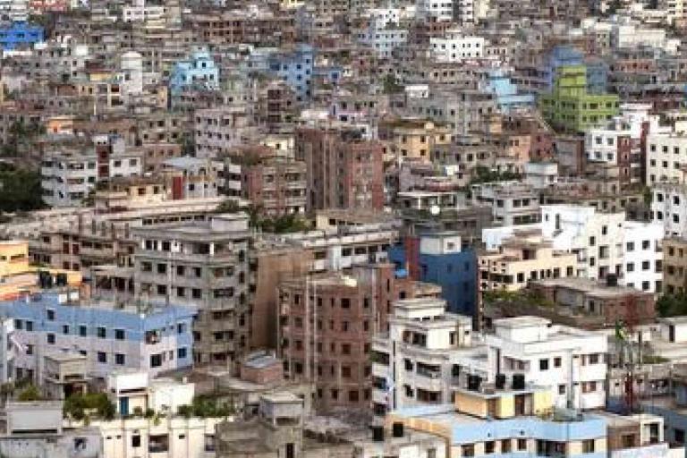 A dense urban area with many closely packed multi-story buildings of various colors, showing minimal green spaces.