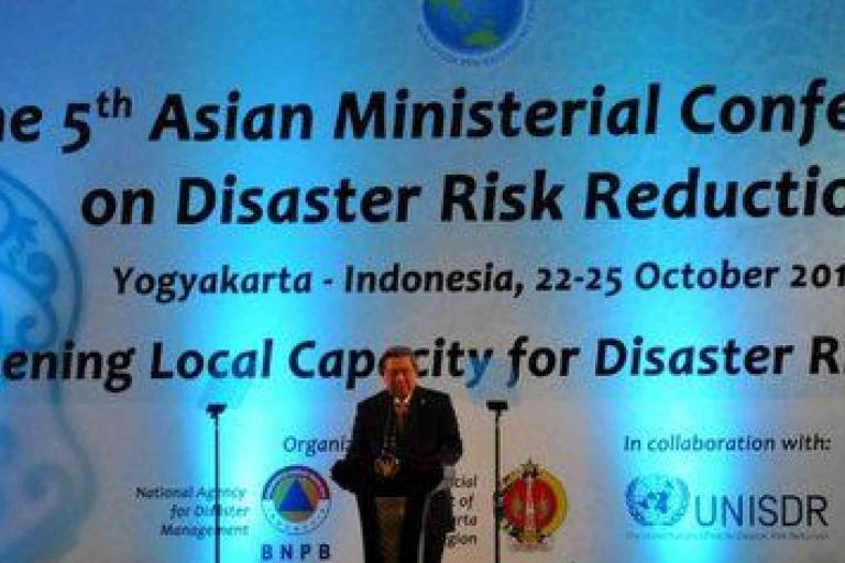 A speaker stands on stage in front of a large banner for the 5th Asian Ministerial Conference on Disaster Risk Reduction held in Yogyakarta, Indonesia, October 22-25, 2012.