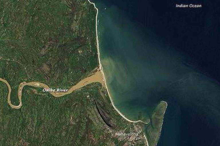Aerial view showing the Umfolozi River flowing into the Indian Ocean near the town of Mtubatuba, with green land and coastal waters visible.
