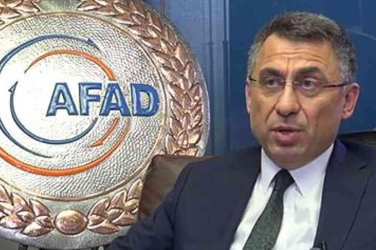 A man in a suit sits in front of a large AFAD emblem mounted on the wall.
