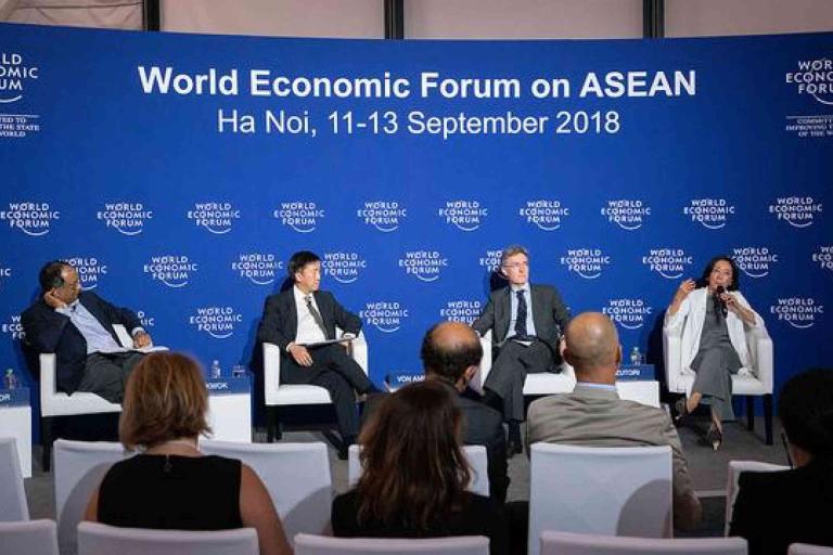 Four panelists speak on stage at the World Economic Forum on ASEAN in Hanoi, Vietnam, held from September 11-13, 2018, with attendees seated in the foreground.