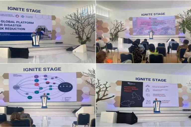 A conference speaker presents slides on disaster risk reduction at the IGNITE STAGE, with attendees seated and watching in a brightly lit room.