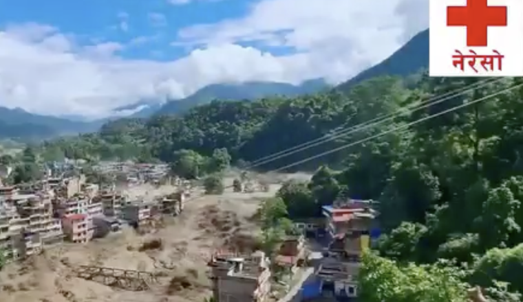 A flooded river runs through a town in a mountainous area; damaged buildings and debris are visible. A red cross with Nepali text appears in the top right corner.