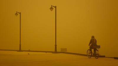 Man cycles in sandstorm in Iraq
