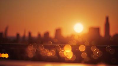 the sun is setting over a city skyline.