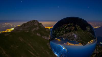 A glass ball on top of a mountain.