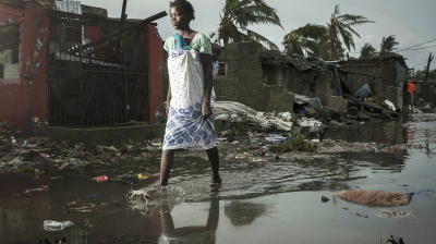 A woman walks through a flooded street in haiti.