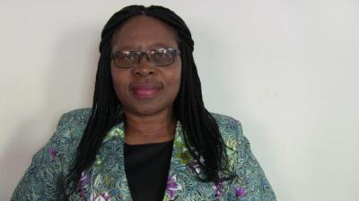 A woman wearing glasses and a colorful jacket.