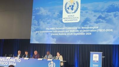 Panelists sit at a long table in front of a large screen at the WMO Technical Conference on meteorological instruments, Vienna, 2024.