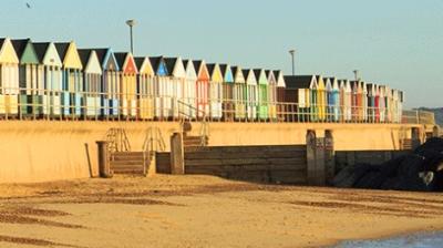 A row of colorful huts on a beach.