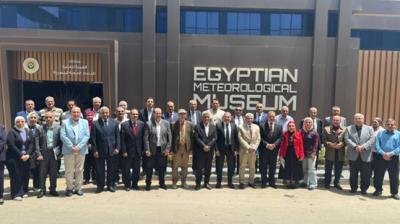 A large group of people stands in front of the Egyptian Meteorological Museum building for a group photo.