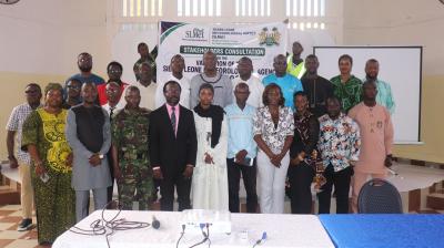 A group of people standing for a photo in front of a banner for a Sierra Leone Meteorological Agency stakeholders consultation.