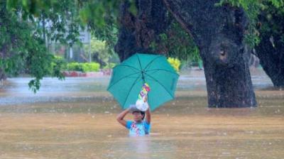 Residents of Korociri settlement cross through the flooded Nadi backroad in Fiji. Photo: Fiji Government