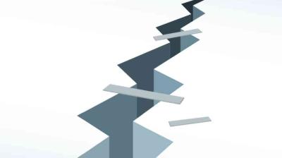 A deep, jagged crack runs through a flat, white surface with a few narrow planks laid across the gap.