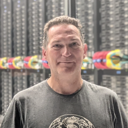 A man standing in front of a server room.