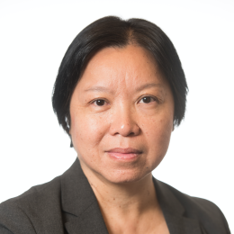 An asian woman in a suit poses for a photo.