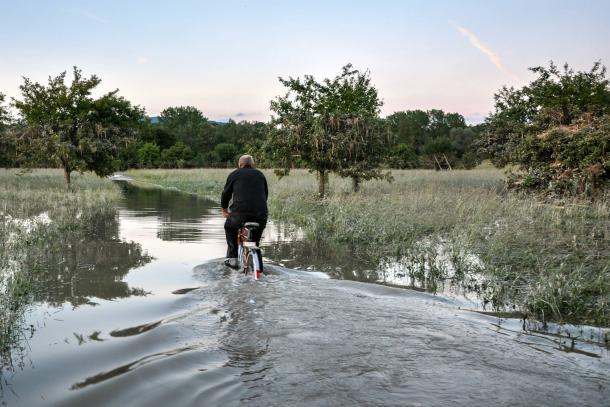 A man riding his bicycle in a flood