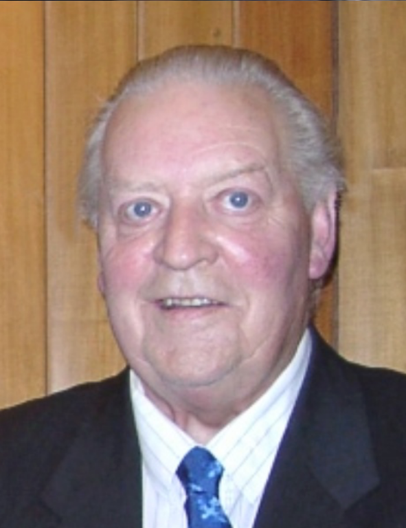 An older man in a suit and tie.