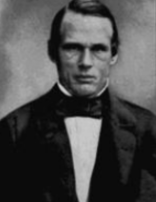 A black and white photo of a man in a tuxedo.
