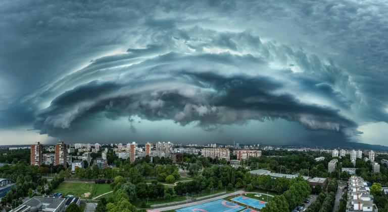 A large storm cloud is seen over a city.