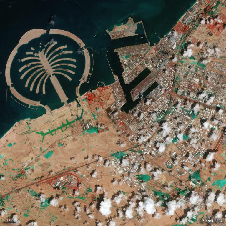 Aerial satellite image of a coastline with a palm-shaped artificial island next to an urban area, taken on april 17, 2024.