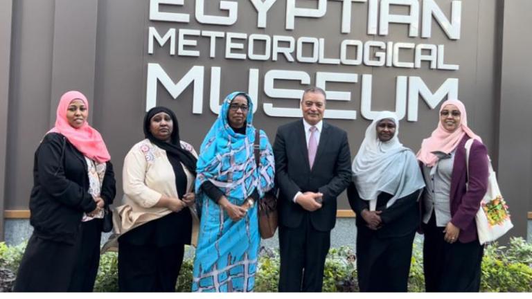 Group of six people posing in front of the egyptian meteorological museum sign.