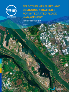 Aerial view of a river flowing through urban and rural areas with the cover text "designing strategies for integrated flood management, april 2017" by esquire paradigm, world bank group.