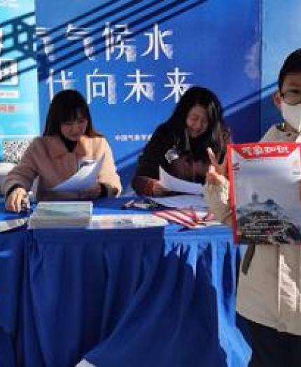 children received the magazine of Meteorological Knowledge in the park of CMA in Beijing. 