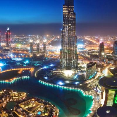 The burj khalifa tower is lit up at night.