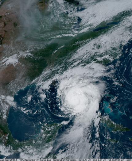 Satellite image showing two hurricanes over the Atlantic Ocean and the Gulf of Mexico, with visible cloud formations and weather patterns over the eastern United States and the Caribbean.