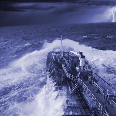 A ship in rough seas navigates through dark, stormy conditions with lightning flashing in the distant sky.