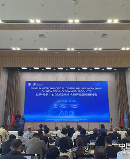 Conference room with people attending the World Meteorological Centre Beijing Workshop on new technology and products. Large screen displays workshop details.