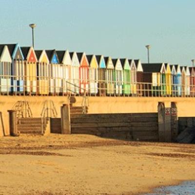 A row of colorful huts on a beach.