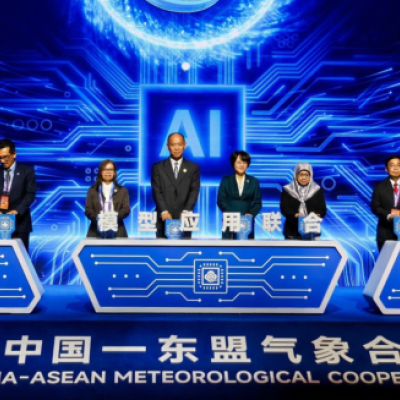 A group of officials stands behind podiums on stage at the 4th China-ASEAN Meteorological Cooperation Forum with a digital AI-themed backdrop.