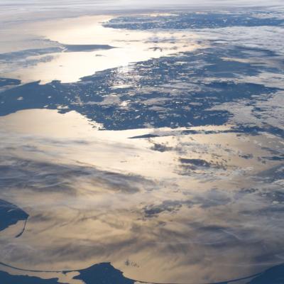 A view of northwestern Europe from space, with land, clouds, and sunlight reflecting off the surrounding sea.