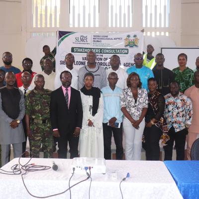 A group of people standing for a photo in front of a banner for a Sierra Leone Meteorological Agency stakeholders consultation.